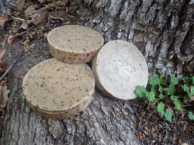 Homemade soap bars on tree log. 