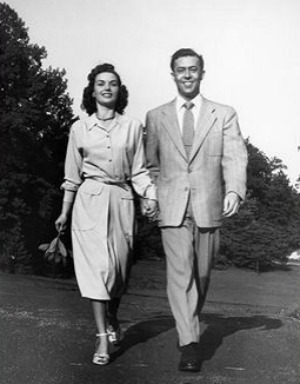 Vintage man and woman smiling while walking and holding hands.