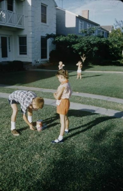 Vintage kids lighting fireworks in the yard.