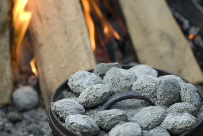 Dutch oven coals charcoal near bonfire outdoor cooking.