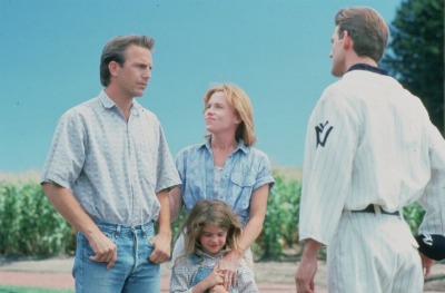 Kevin Costner chatting to a person along with family in movie "field of dreams".