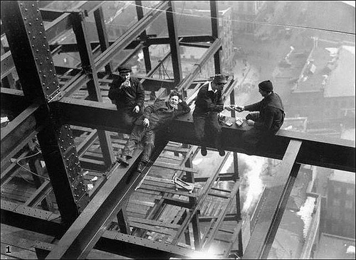 blue vintage men steelworkers resting on skyscraper beams