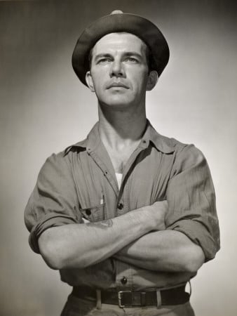 Vintage working class man standing while wearing hat.