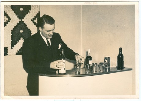 Vintage man serving drinks at home bar.