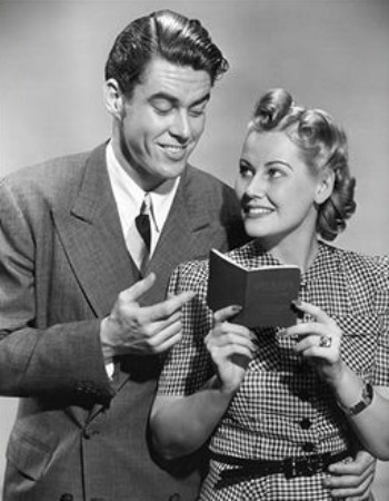 Vintage young couple looking at each other while women holding book.