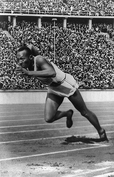 Jesse Owens running in the track field stadium for action shot.