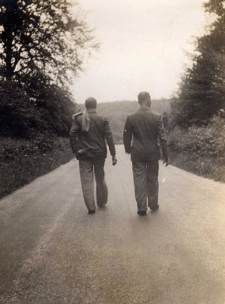 Two men walking on the road.