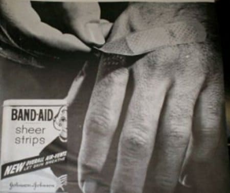 Vintage man ripping off his hand with band aid.