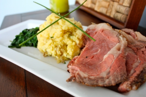 Rib roast and potatoes and greens in the tray.