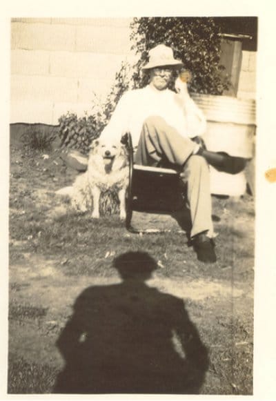 Vintage man sitting in the yard with his dog. 