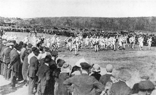 Vintage country racing and crowd around the race course.