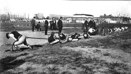 Vintage young men pulling ropes.