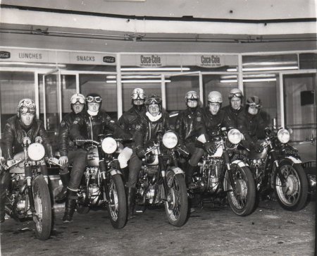 Vintage group of motorcycle riders wearing leather jackets and scarves.
