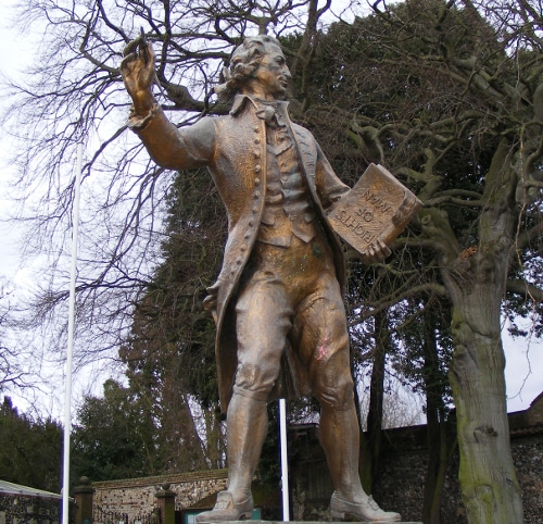 Thomas Paine bronze statue holding pen and book in hand.