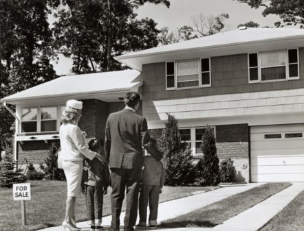 homeownership Vintage family standing in front of house.