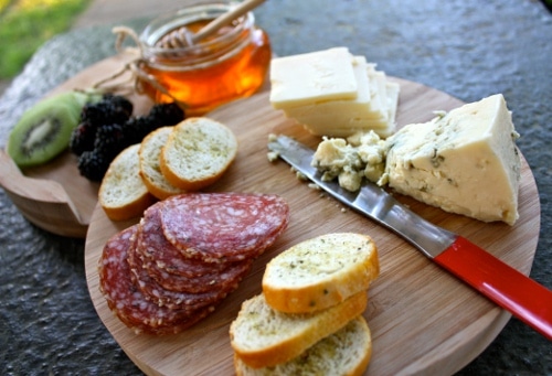 Cheese board of food items with knife.