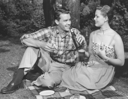 Vintage couple drinking beer on picnic. 