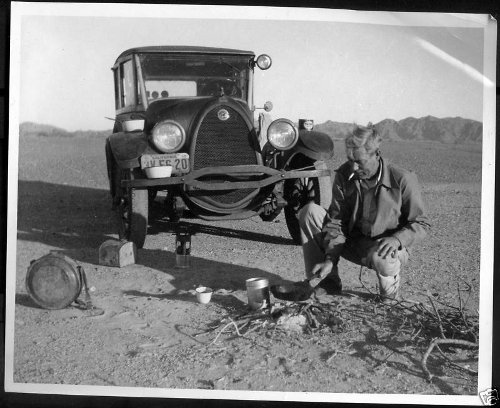 Vintage man cooking in front of car at outside.