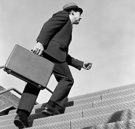 Vintage man walking through the stairs and holding briefcase.