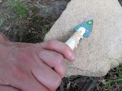 Vintage abrading the edges of this point against the stone to sharpen.