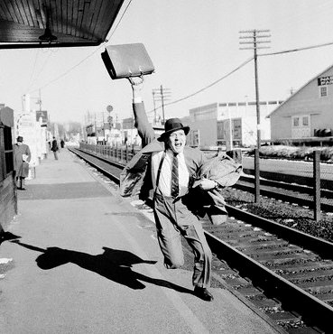 Vintage man businessman suit running after train.