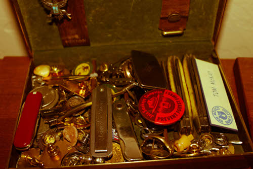 Man's treasure box knives coins pins lapels.