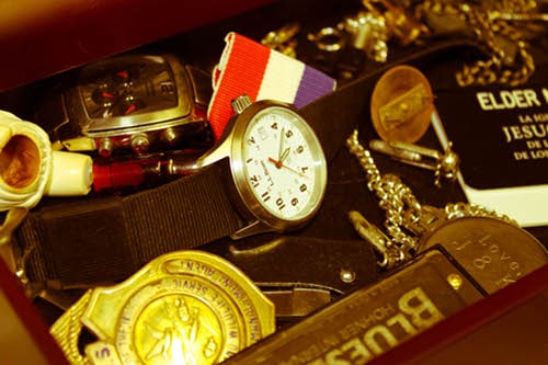 Vintage treasure box watches and coins placed at table.