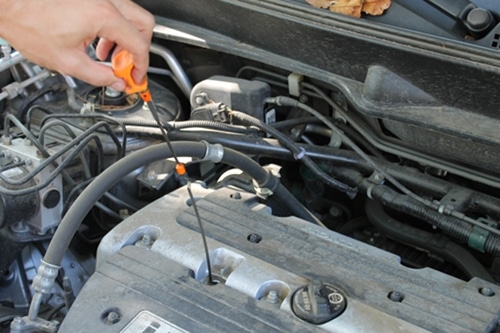 removing dip stick from engine check oil level 