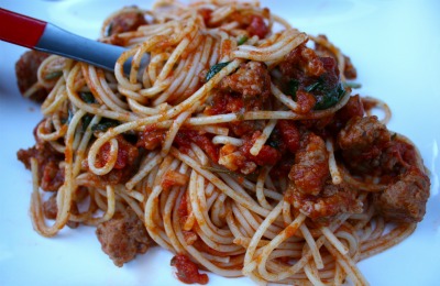 Fresh pasta spaghetti with red meat sauce close up photo.