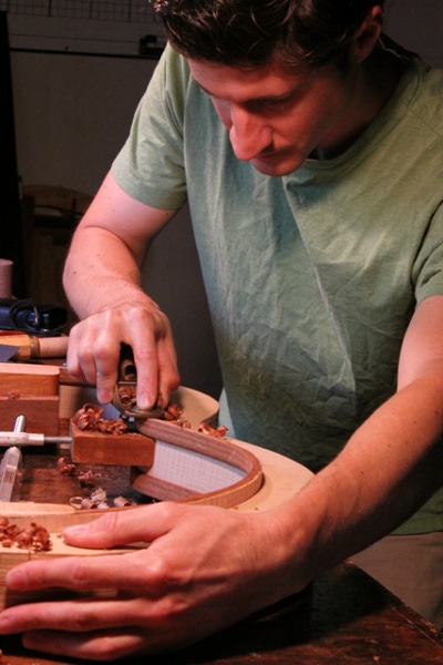 Luthier assembling guitar. 