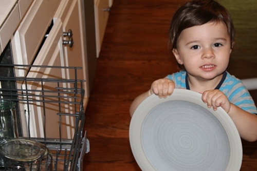 IMG_1061 young boy doing chores holding plate emptying dishwasher