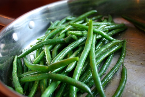 Cooking green beans on skillet oil and salt. 