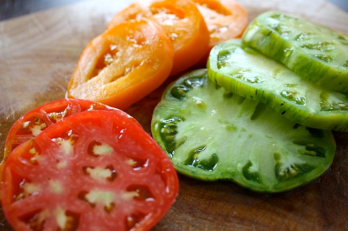 Sliced heirloom tomatoes red orange green vegetables. 