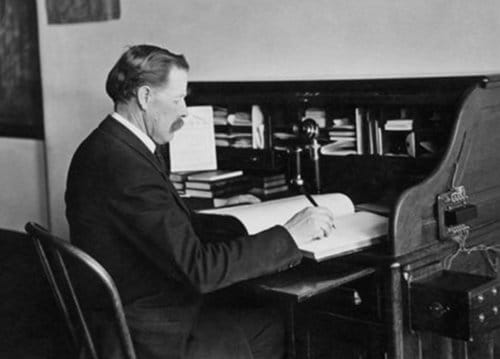 Vintage CEO manager businessman writing in ledger at desk.