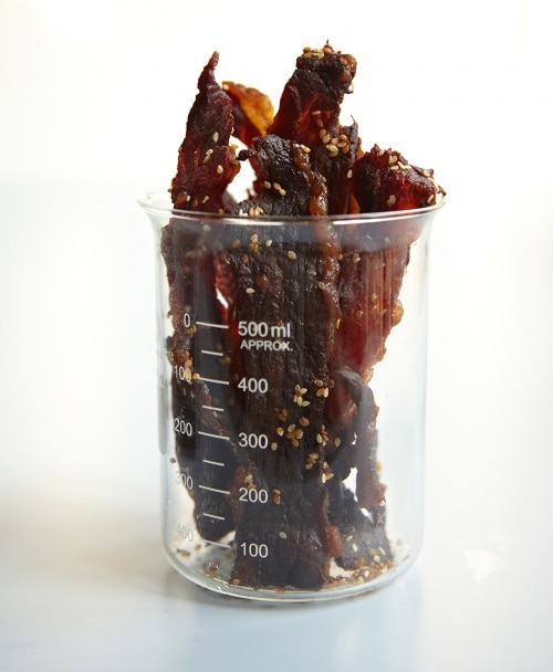 Homemade beef jerky in measuring glass.