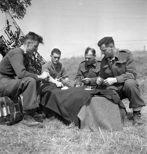 Vintage men playing cribbage outside in field. 