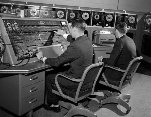 Vintage men working at computers for programming work stations.