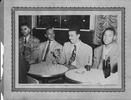 Vintage African American black friends sitting at table talking hanging out.