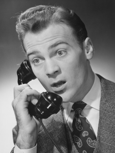 Vintage man attending a telephone call and making surprised look on face.