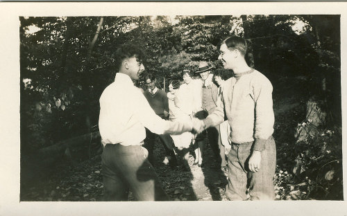 Vintage young men shaking hands smiling. 