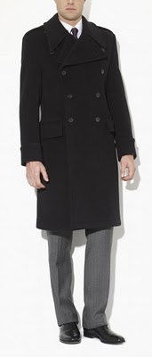 Dark colored paletot overcoat with gray trousers. 