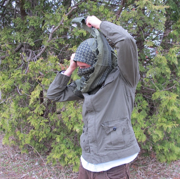 Side view of man tie a military-style scarf Shemagh Keffiyeh.