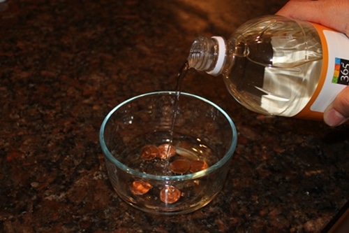 pennies in bowl with vinegar cleaning coins