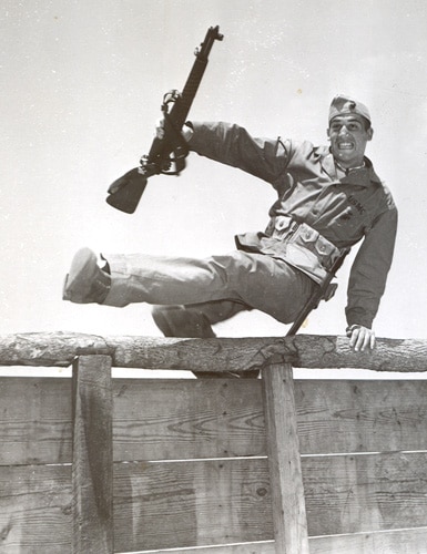 Vintage soldier jumping wooden fence basic training.