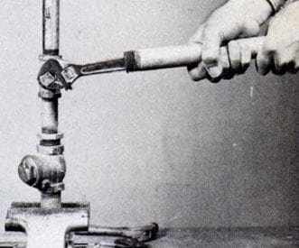 vintage man using wrench cheater bar close up photo