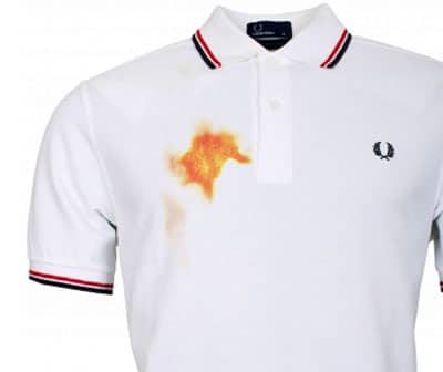 orange yellow mustard stain on white polo shirt 