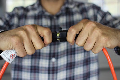 Man connecting male female end of extension cord.