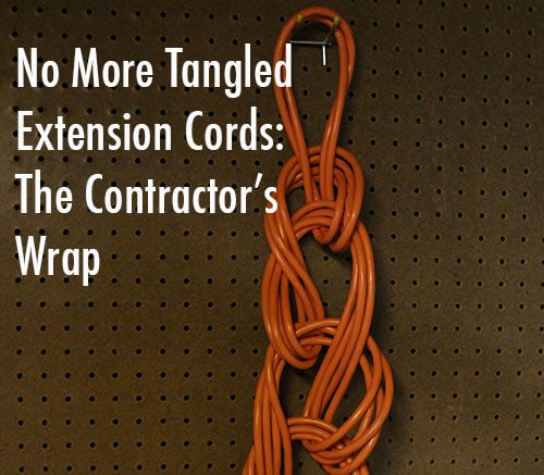 Wrapped extension cord hanging from peg board.