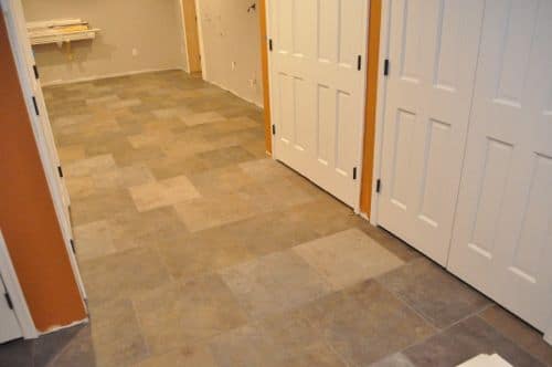 Hallway having three doors with fisnished tiles.