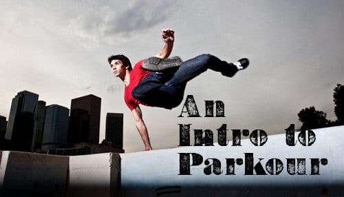 Young man jumping over wall parkour.